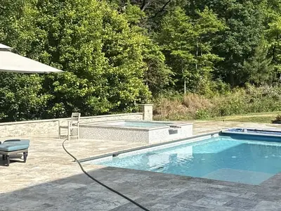 Backyard pool and paver patio with hot tub